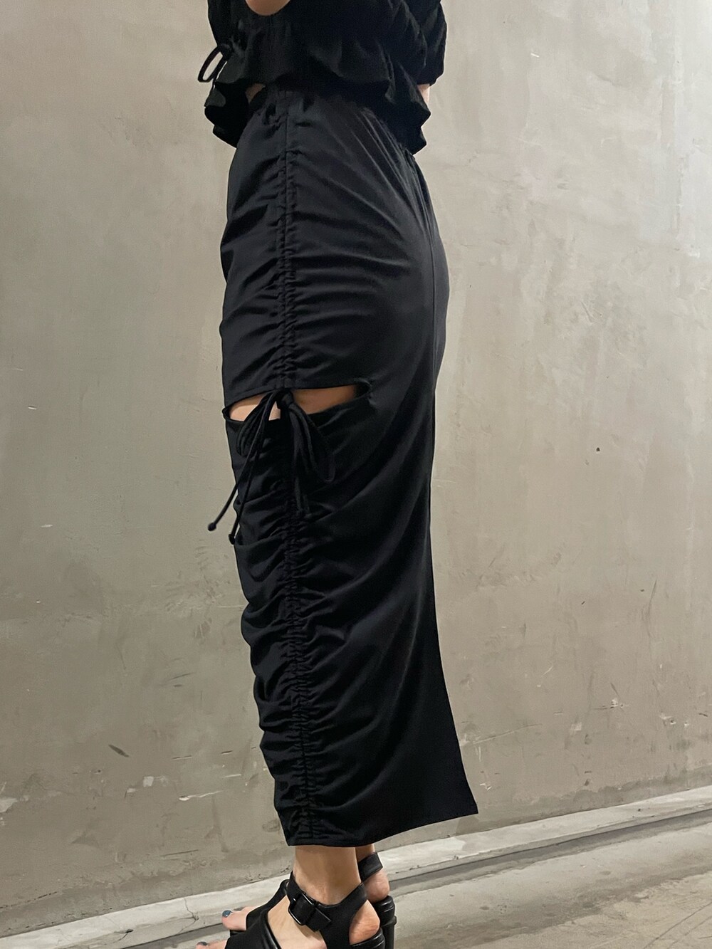 ブラック系のTシャツ/カットソー、ブラック系のスカート、ブラック系のサンダルを着用したレディースの春コーディネートの8枚目の写真