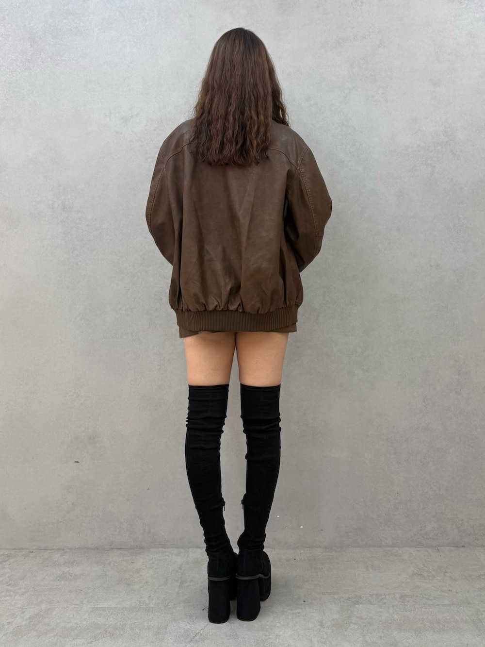 ブラック系のTシャツ/カットソー、ブラウン系のブルゾン、ブラウン系のスカートを着用したレディースの秋コーディネートの3枚目の写真