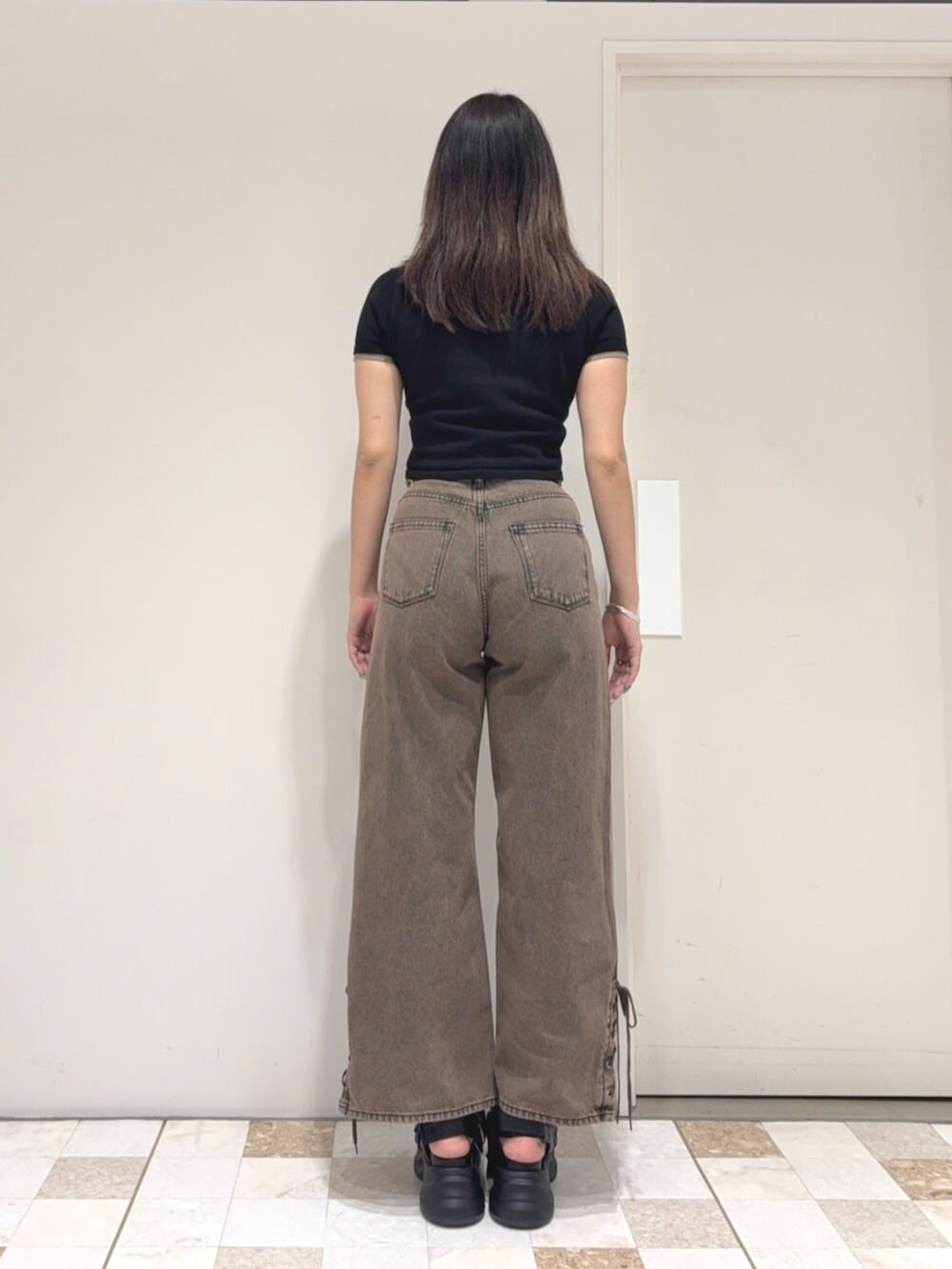 ブラック系のカーディガン/ボレロ、ブラウン系のデニムパンツ、ブラック系のサンダルを着用したレディースの夏コーディネートの3枚目の写真