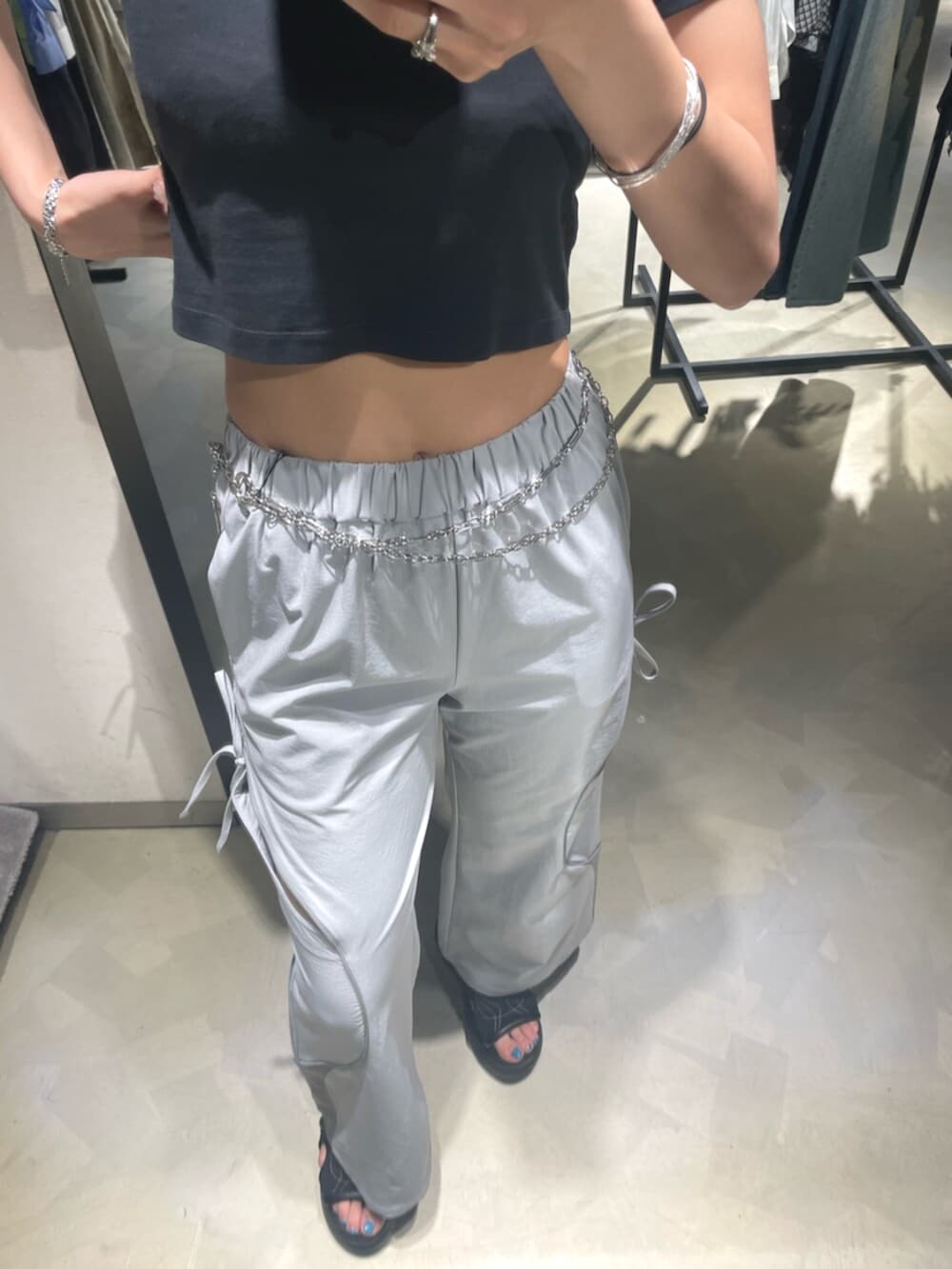 ブラック系のTシャツ/カットソー、グレー系のその他パンツ、ブラック系のサンダルを着用したレディースの春コーディネートの8枚目の写真