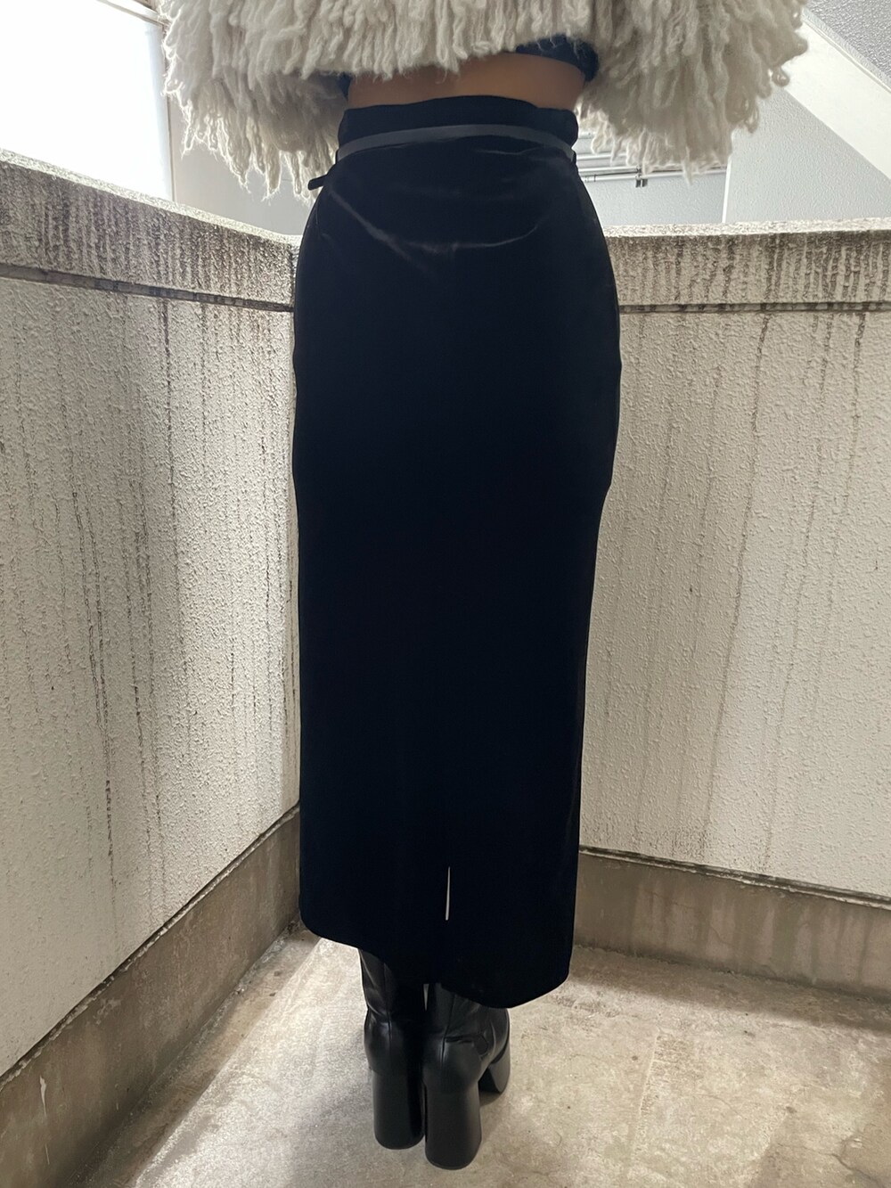 グレー系のニット/セーター、ブラック系のハンドバッグ、ブラック系のスカートを着用したレディースの秋コーディネートの9枚目の写真