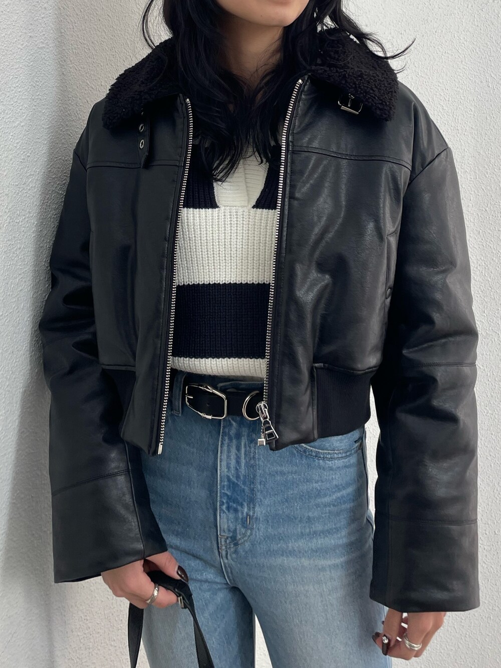 ブラック系のブルゾン、その他のニット/セーター、ブルー系のデニムパンツを着用したレディースの冬コーディネートの4枚目の写真