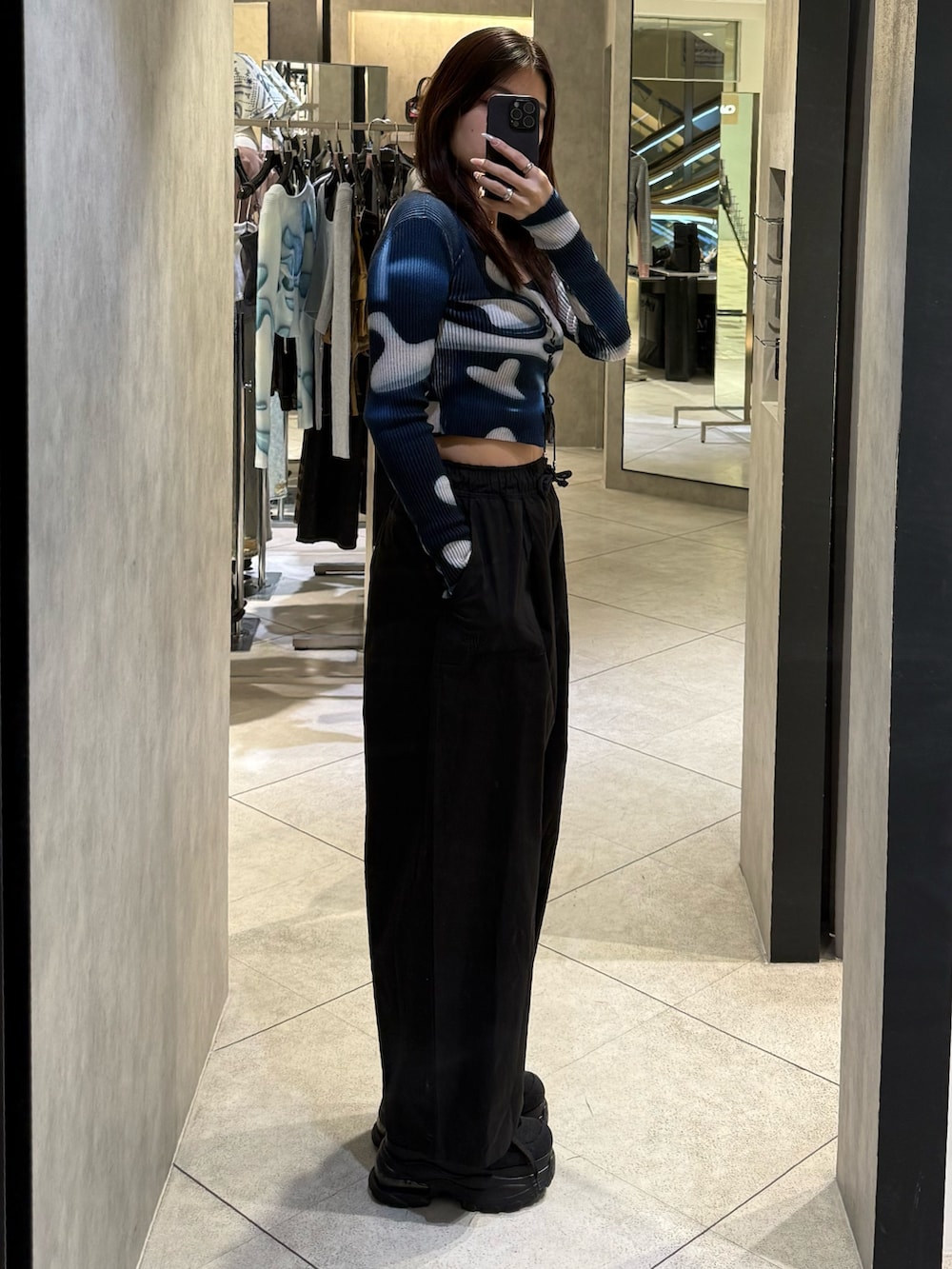 ブラック系のスニーカー、ブラック系のその他パンツ、ブルー系のニット/セーターを着用したレディースの春コーディネートの2枚目の写真