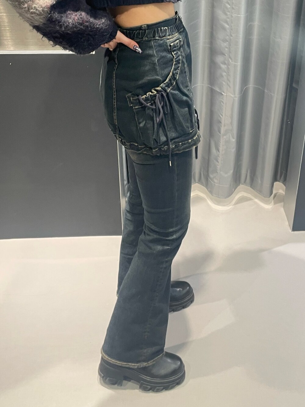 ブルー系のニット/セーター、ブルー系のデニムパンツ、ブラック系のブーツを着用したレディースの秋コーディネートの6枚目の写真