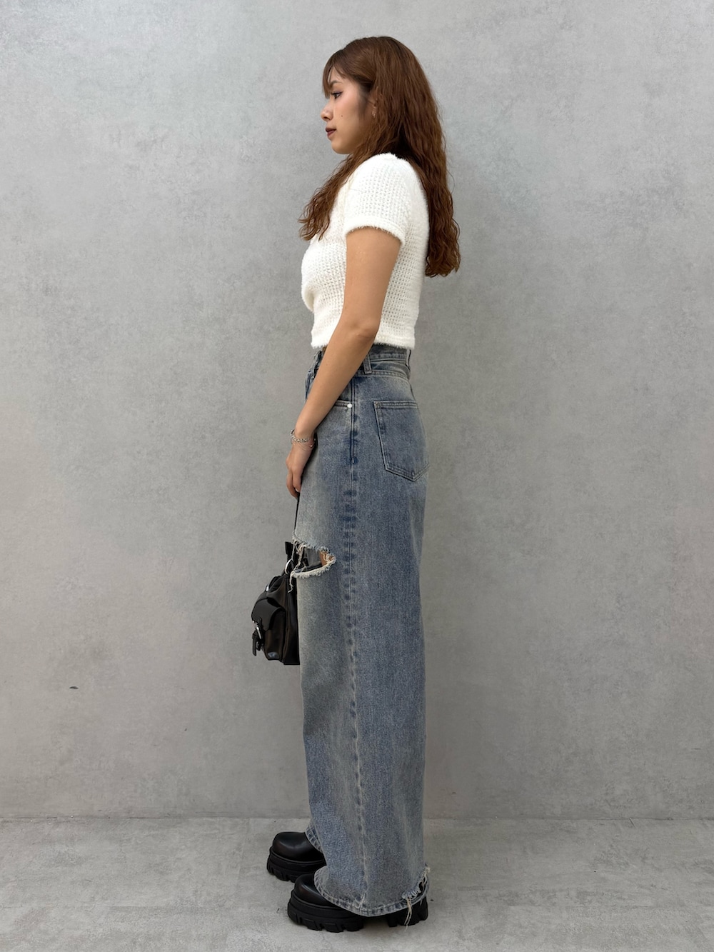 ホワイト系のTシャツ/カットソー、ブルー系のデニムパンツ、ブラック系のハンドバッグを着用したレディースの夏コーディネートの2枚目の写真