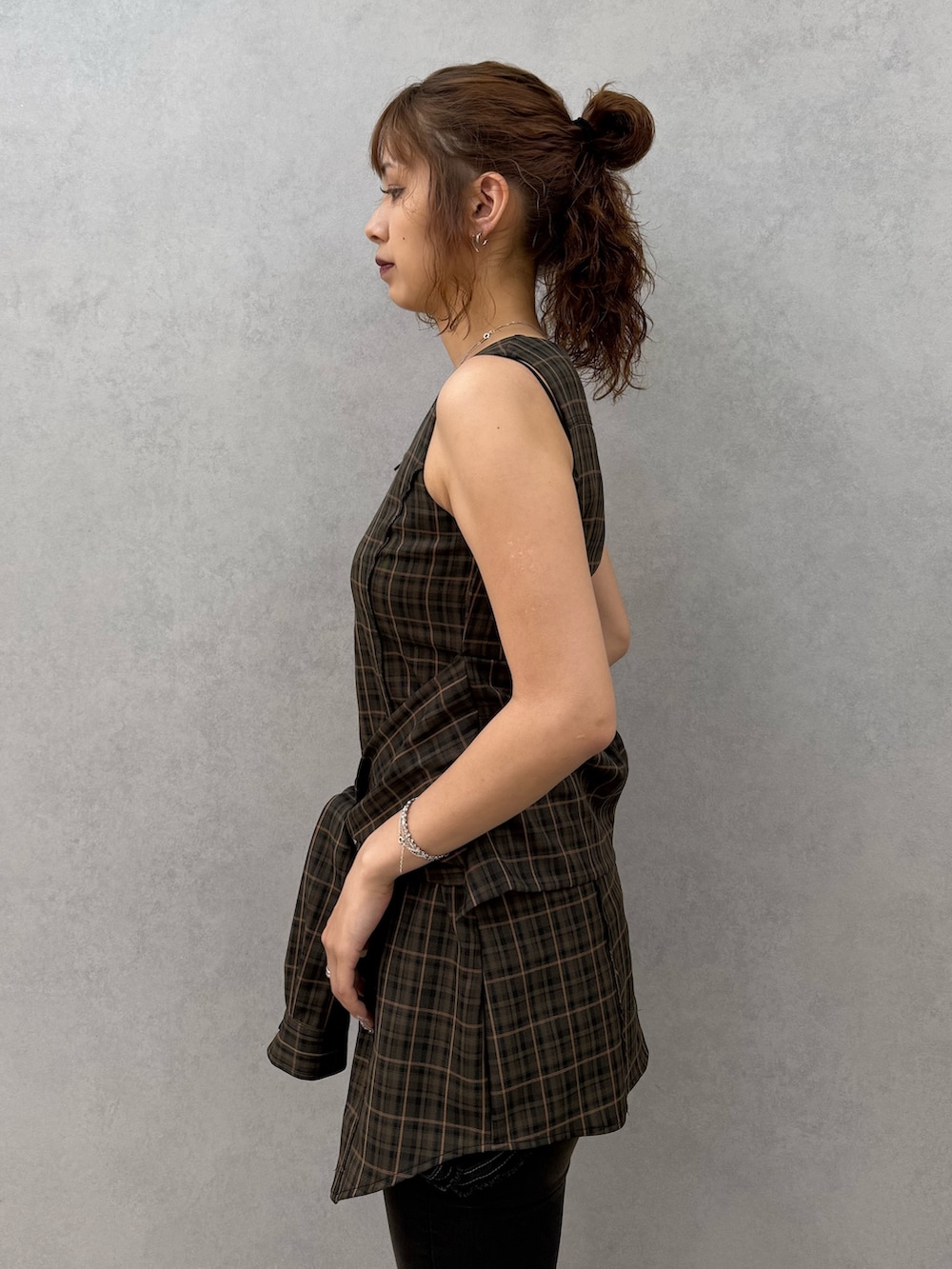 ブラウン系のワンピース、ブラック系のデニムパンツ、ブラック系のサンダルを着用したレディースの夏コーディネートの5枚目の写真