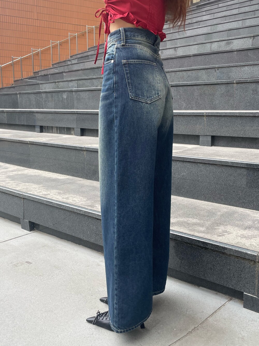 レッド系のTシャツ/カットソー、ブルー系のデニムパンツ、ブラック系のハンドバッグを着用したレディースの春コーディネートの8枚目の写真