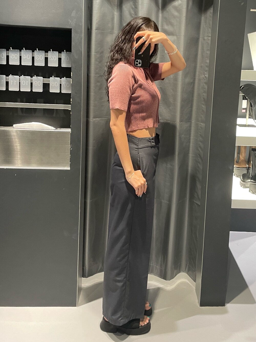 ピンク系のニット/セーター、グレー系のその他パンツ、ブラック系のサンダルを着用したレディースの夏コーディネートの2枚目の写真