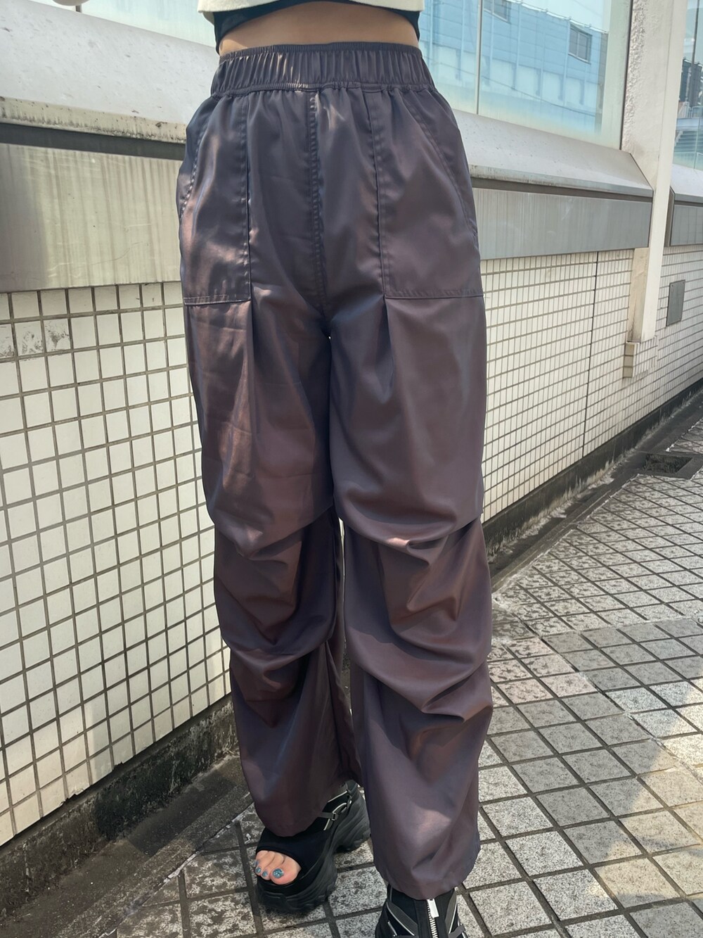 ブラック系のハンドバッグ、ブラック系のTシャツ/カットソー、ブラウン系のその他パンツを着用したレディースの春コーディネートの7枚目の写真