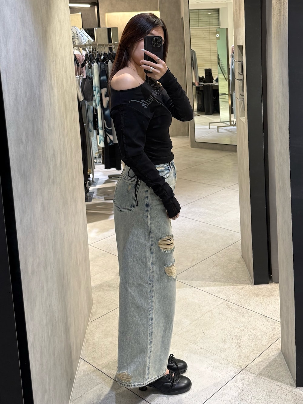 ブラック系のTシャツ/カットソー、ブルー系のデニムパンツ、ブラック系のスニーカーを着用したレディースの春コーディネートの2枚目の写真