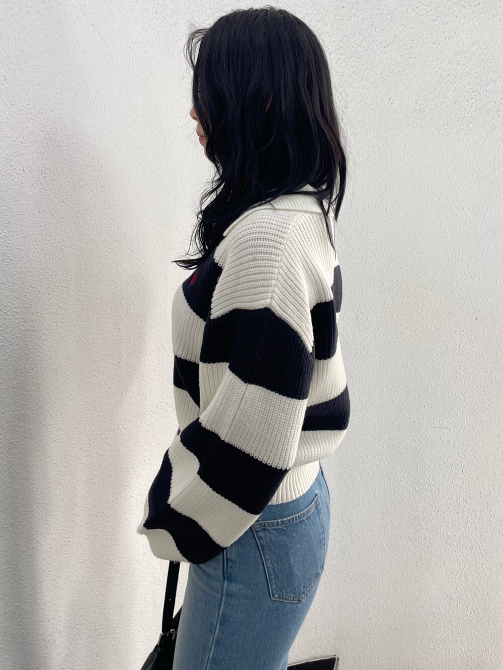 ブラック系のブルゾン、その他のニット/セーター、ブルー系のデニムパンツを着用したレディースの冬コーディネートの7枚目の写真