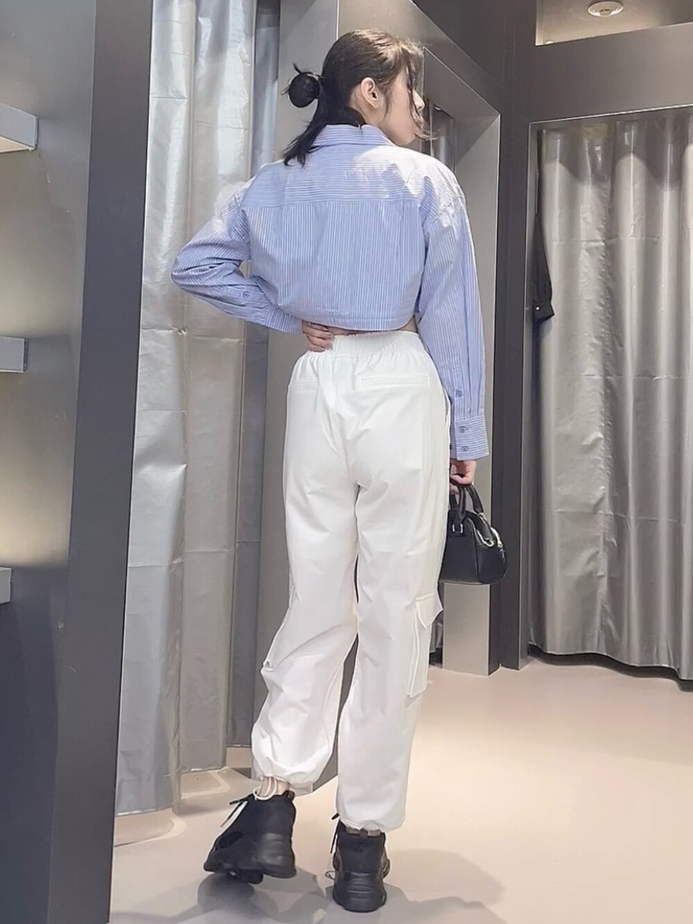 ブラック系のTシャツ/カットソー、ブルー系のシャツ/ブラウス、ブラック系のハンドバッグを着用したレディースの春コーディネートの3枚目の写真