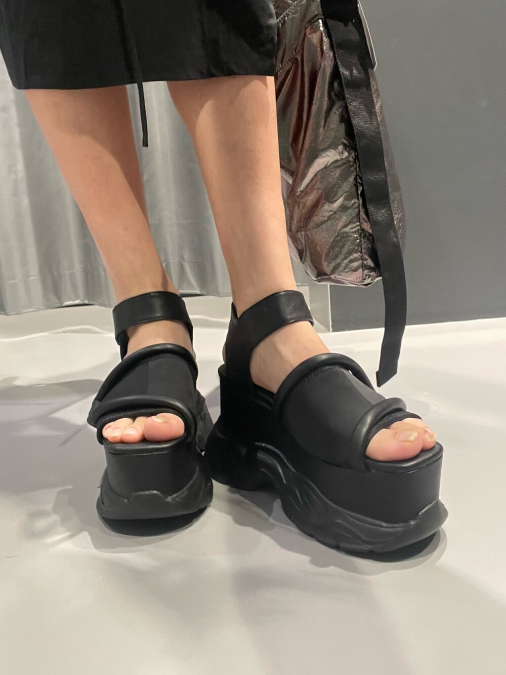 ブラック系のワンピース、グレー系のハンドバッグ、ブラック系のサンダルを着用したレディースの春コーディネートの9枚目の写真