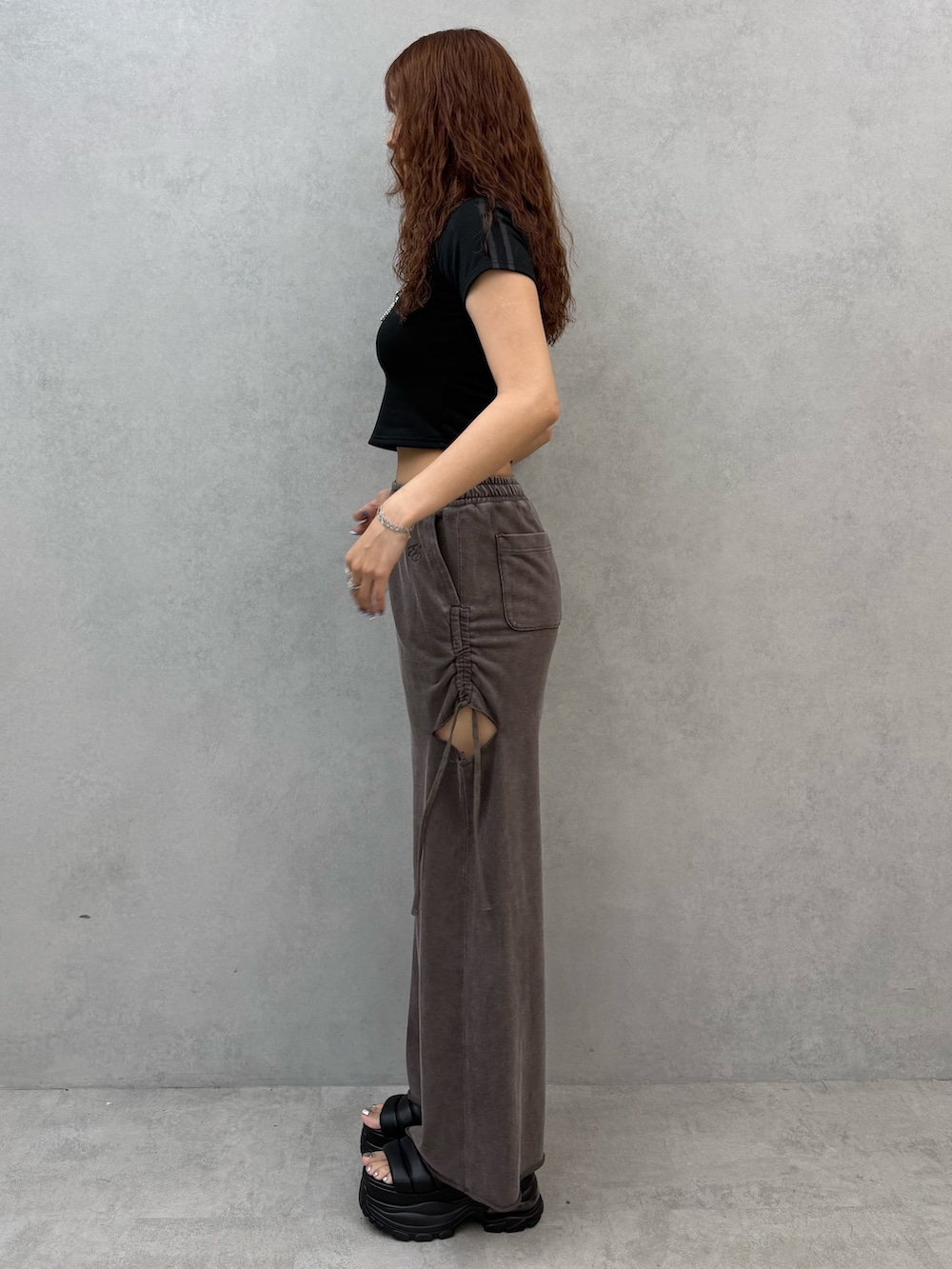 ブラック系のTシャツ/カットソー、ブラウン系のスウェットパンツ、ブラック系のサンダルを着用したレディースの夏コーディネートの2枚目の写真