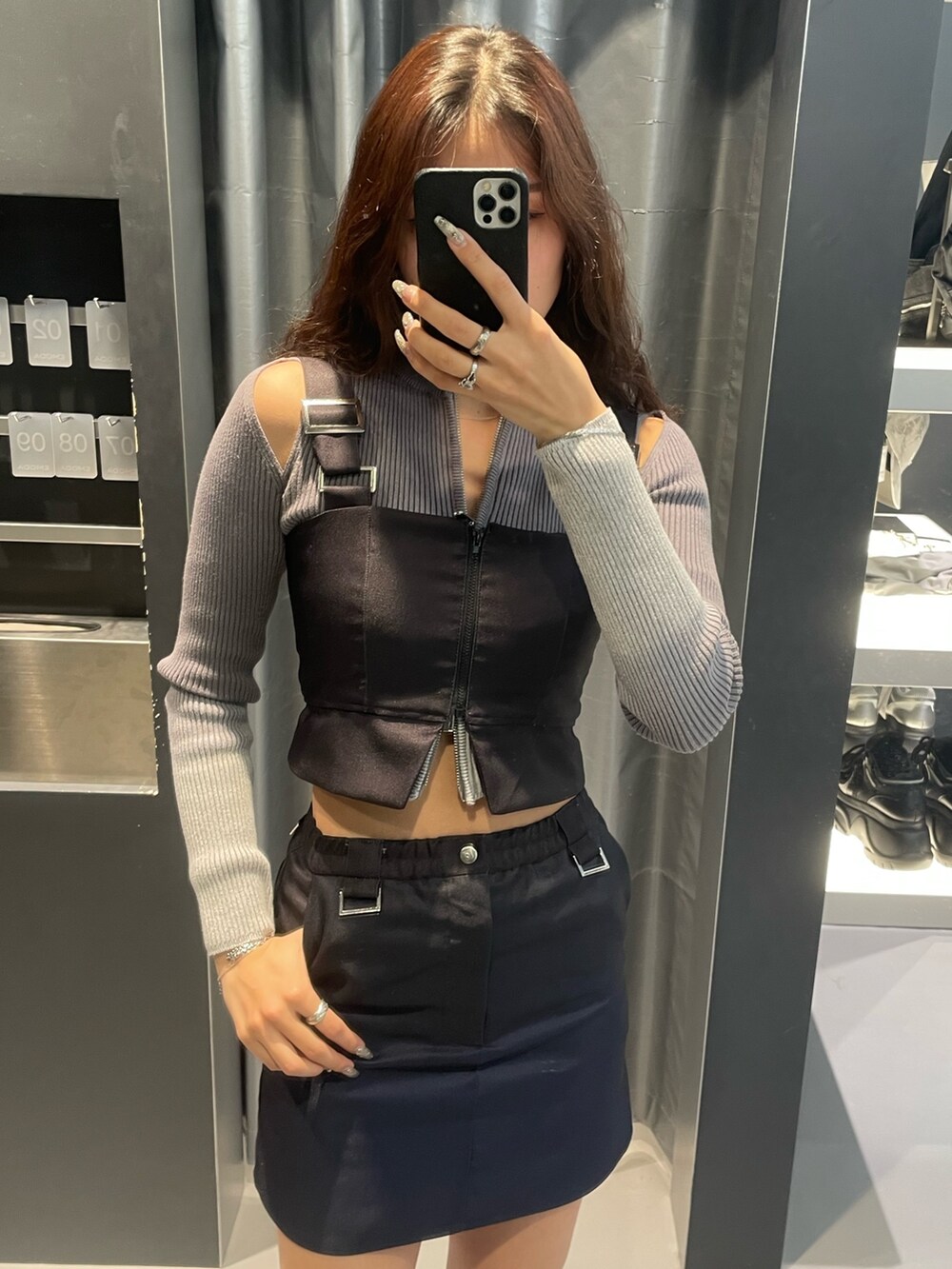 グレー系のニット/セーター、ブルー系のスカート、シルバー系のスニーカーを着用したレディースの冬コーディネートの4枚目の写真