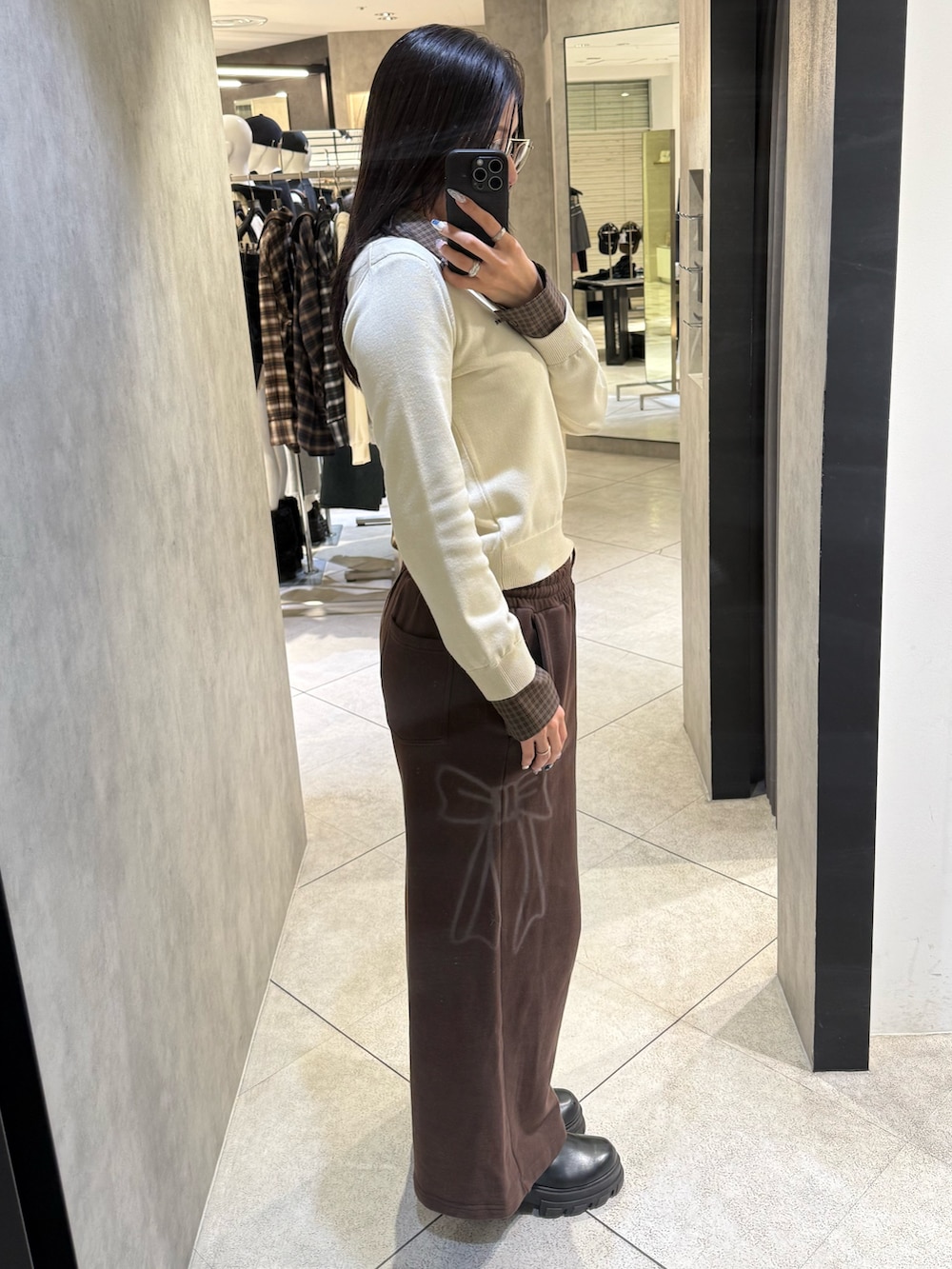 ベージュ系のシャツ/ブラウス、ブラウン系のスウェットパンツ、ブラック系のブーツを着用したレディースの冬コーディネートの2枚目の写真