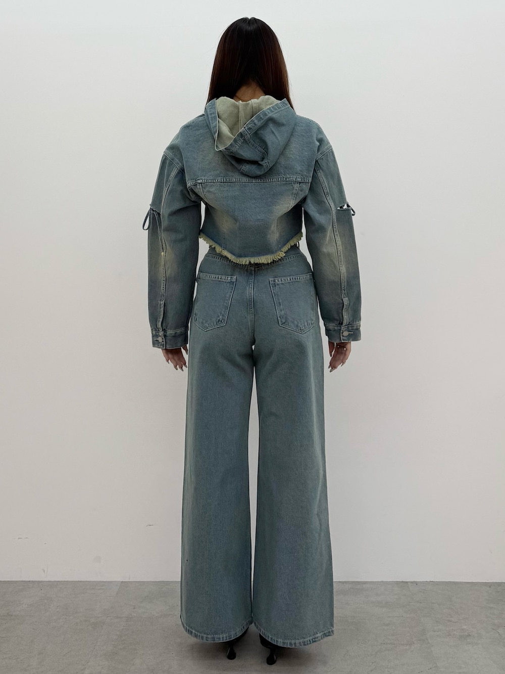 ブルー系のデニムジャケット、ブルー系のデニムパンツ、ブラック系のスニーカーを着用したレディースの冬コーディネートの3枚目の写真