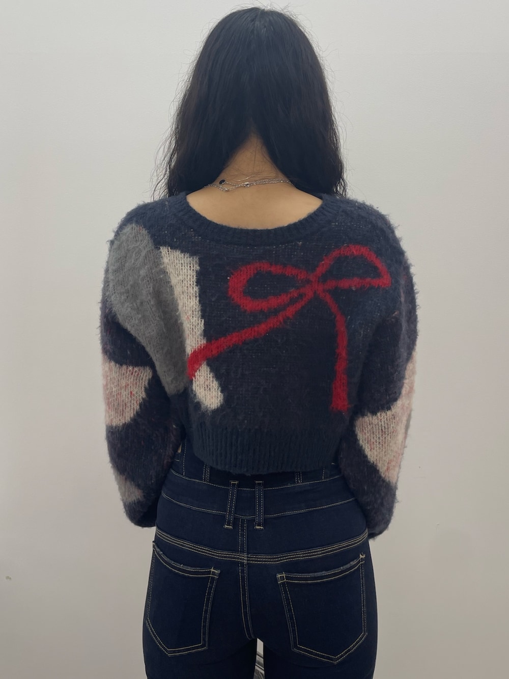 ブルー系のニット/セーター、ブルー系のデニムパンツ、ブラック系のブーツを着用したレディースの夏コーディネートの6枚目の写真