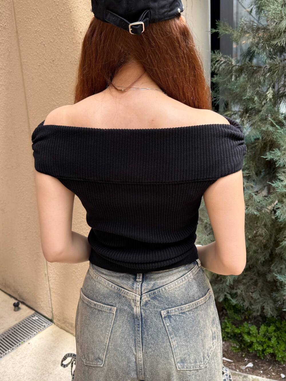 ブラック系のニット/セーター、ブルー系のデニムパンツ、ブラック系のサンダルを着用したレディースの夏コーディネートの6枚目の写真