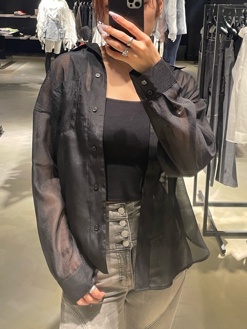 ブラック系のシャツ/ブラウス、ブラック系のニット/セーター、ブラック系のデニムパンツを着用したレディースの春コーディネートの4枚目の写真