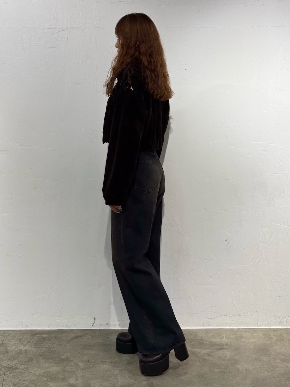 ホワイト系のニット/セーター、ブラック系のブルゾン、ブルー系のデニムパンツを着用したレディースの秋コーディネートの2枚目の写真