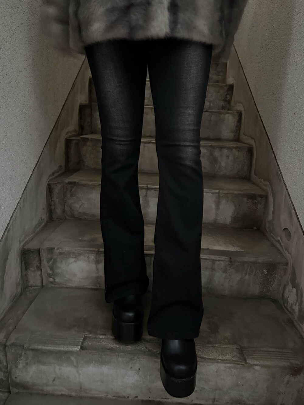 ホワイト系のニット/セーター、ブラック系のデニムパンツ、ブラック系のブーツを着用したレディースの秋コーディネートの5枚目の写真