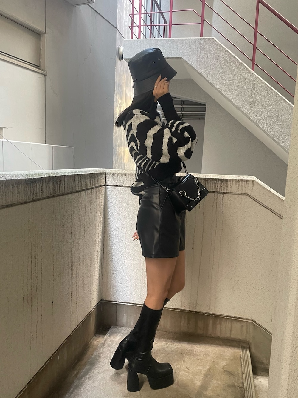 ブラック系のニット/セーター、ブラック系のその他パンツ、ブラック系のブーツを着用したレディースの冬コーディネートの2枚目の写真