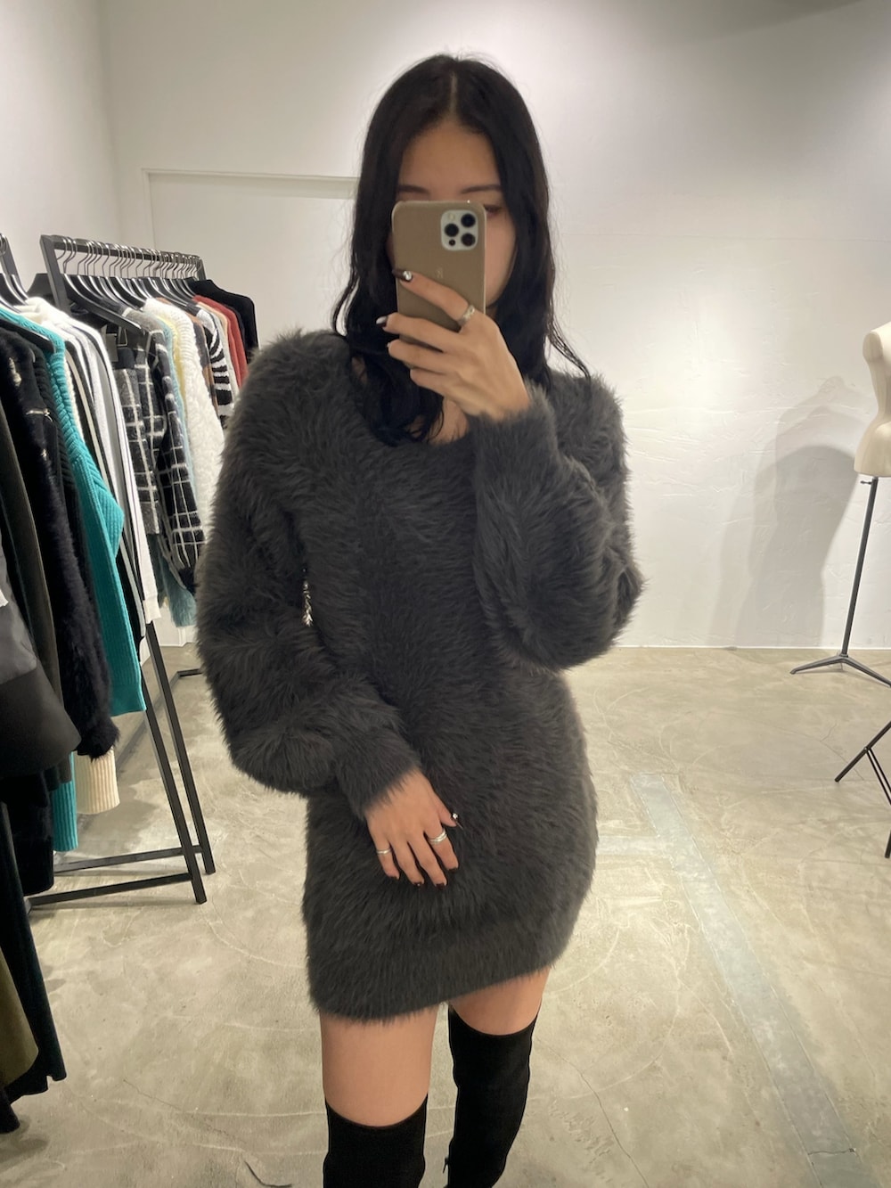 ブラック系のピーコート、グレー系のワンピース、ブラック系のブーツを着用したレディースの冬コーディネートの4枚目の写真