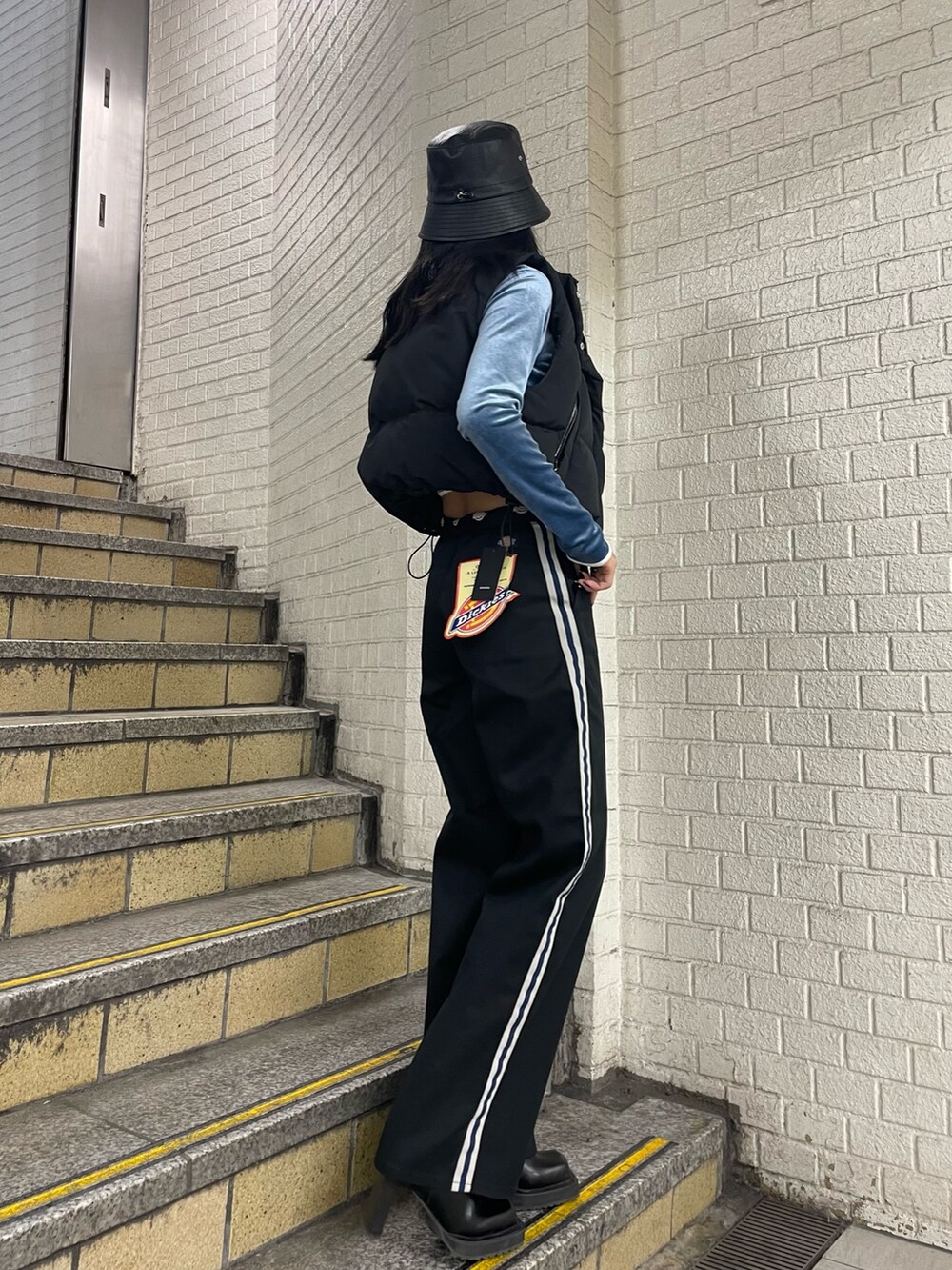 ブラック系のダウンベスト、ブルー系のTシャツ/カットソー、ブラック系のその他パンツを着用したレディースの秋コーディネートの2枚目の写真