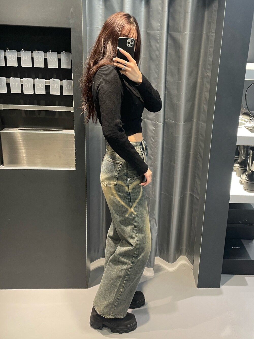 ブラック系のニット/セーター、ブルー系のデニムパンツ、ブラック系のブーツを着用したレディースの冬コーディネートの2枚目の写真