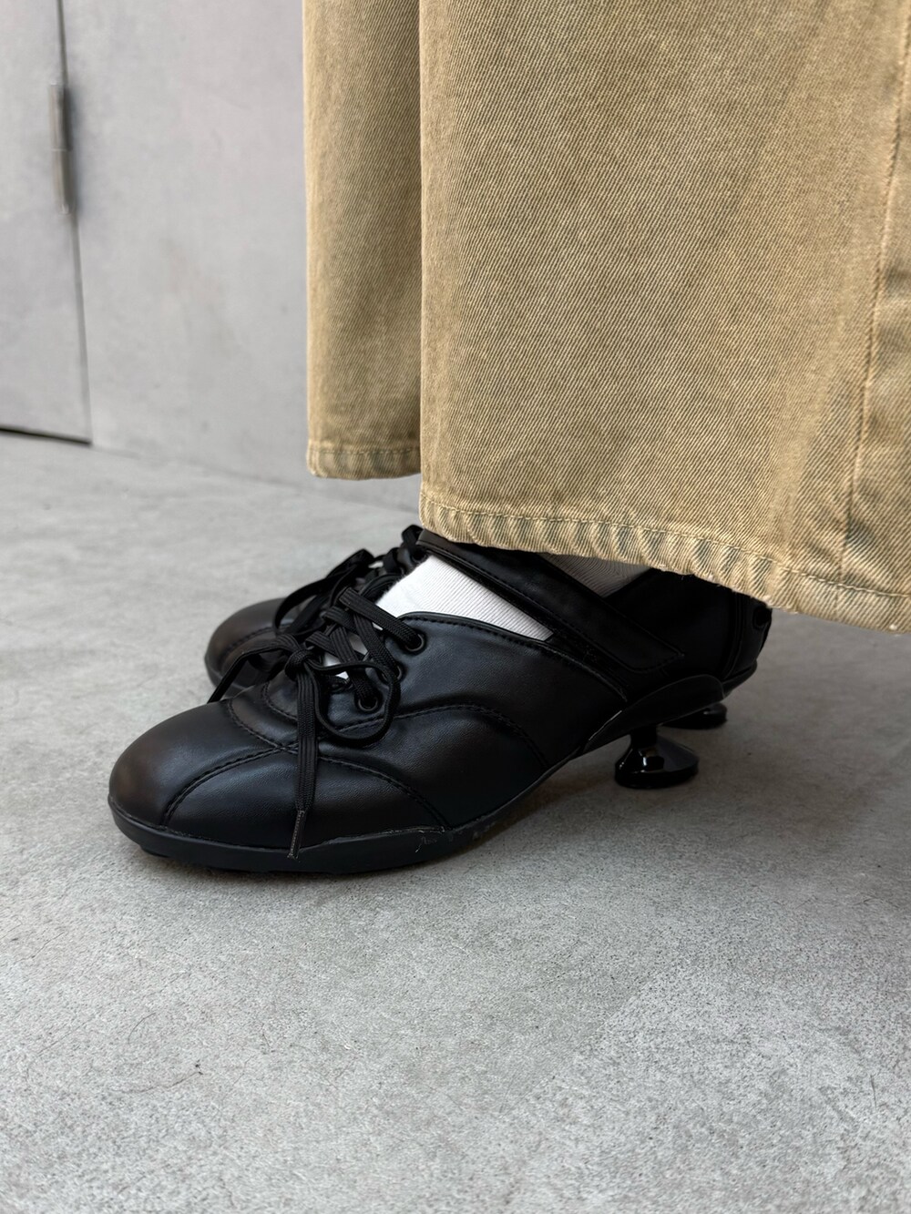 ブラック系のシャツ/ブラウス、ベージュ系のデニムパンツ、ブラック系のスニーカーを着用したレディースの冬コーディネートの6枚目の写真