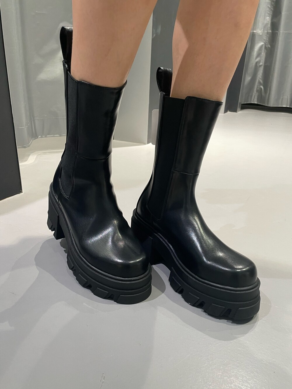 ブラック系のシャツ/ブラウス、ホワイト系のデニムパンツ、ブラック系のブーツを着用したレディースの春コーディネートの7枚目の写真