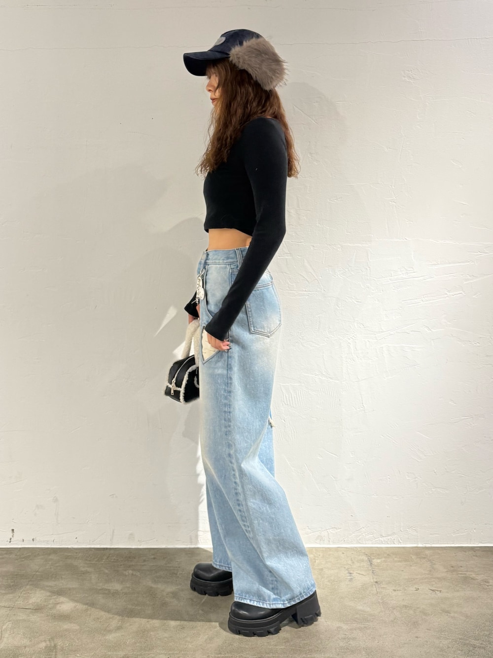 ブラック系のTシャツ/カットソー、ブルー系のデニムパンツ、ブラック系のハンドバッグを着用したレディースの秋コーディネートの2枚目の写真