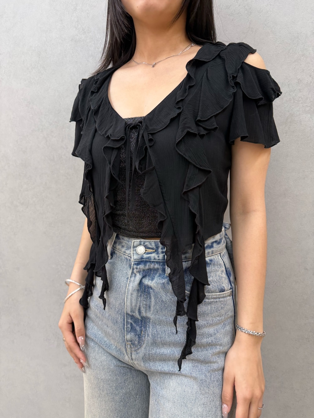 ブラック系のTシャツ/カットソー、ブラック系のキャミソール、ブルー系のデニムパンツを着用したレディースの春コーディネートの4枚目の写真