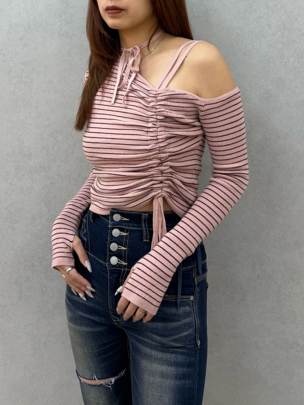 ピンク系のニット/セーター、ブルー系のデニムパンツ、ブラック系のサンダルを着用したレディースの冬コーディネートの4枚目の写真