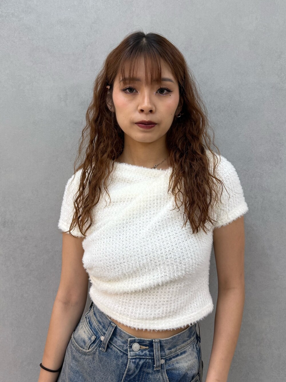 ホワイト系のTシャツ/カットソー、ブルー系のデニムパンツ、ブラック系のブーツを着用したレディースの夏コーディネートの4枚目の写真