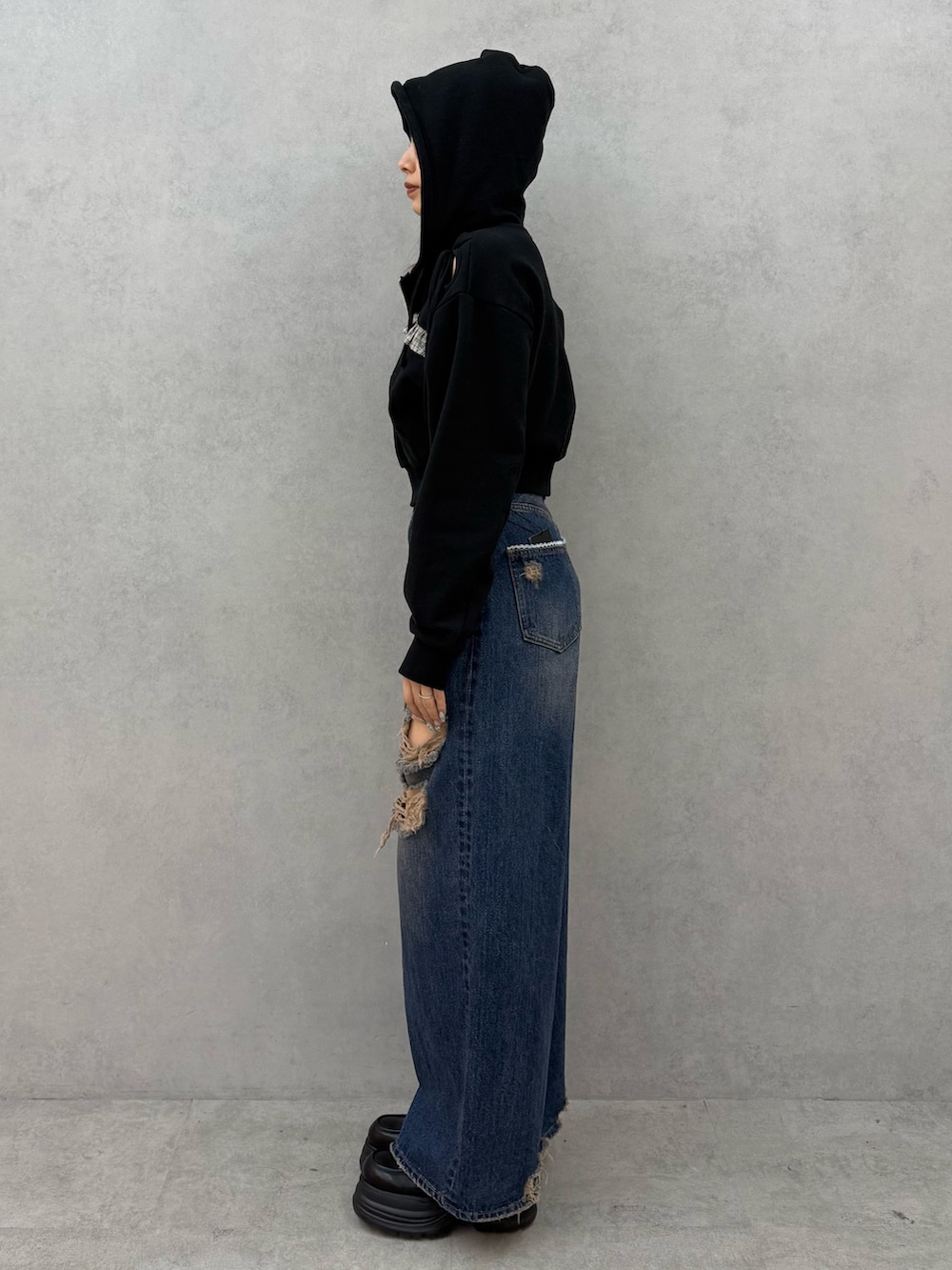 ブラック系のパーカー、ブルー系のデニムパンツ、ブラック系のローファーを着用したレディースの冬コーディネートの2枚目の写真