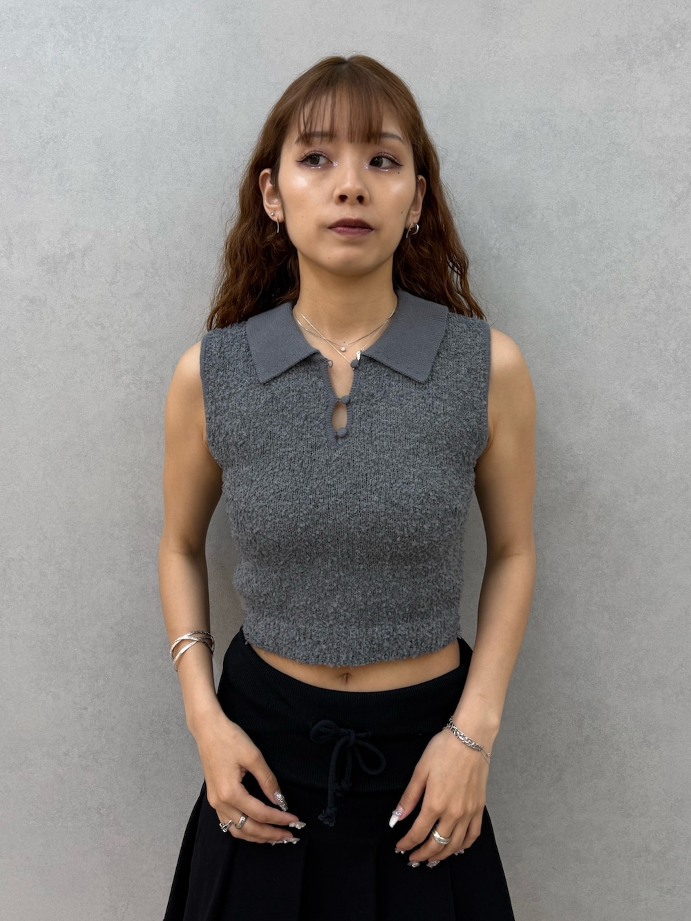 ブラック系のスカート、ブラック系のサンダル、グレー系のニット/セーターを着用したレディースの夏コーディネートの4枚目の写真