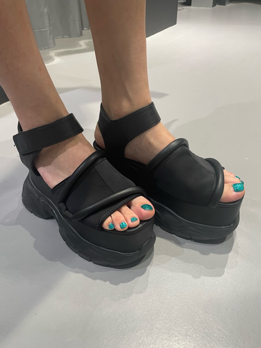 ホワイト系のTシャツ/カットソー、ブラック系のスカート、ブラック系のサンダルを着用したレディースの夏コーディネートの8枚目の写真