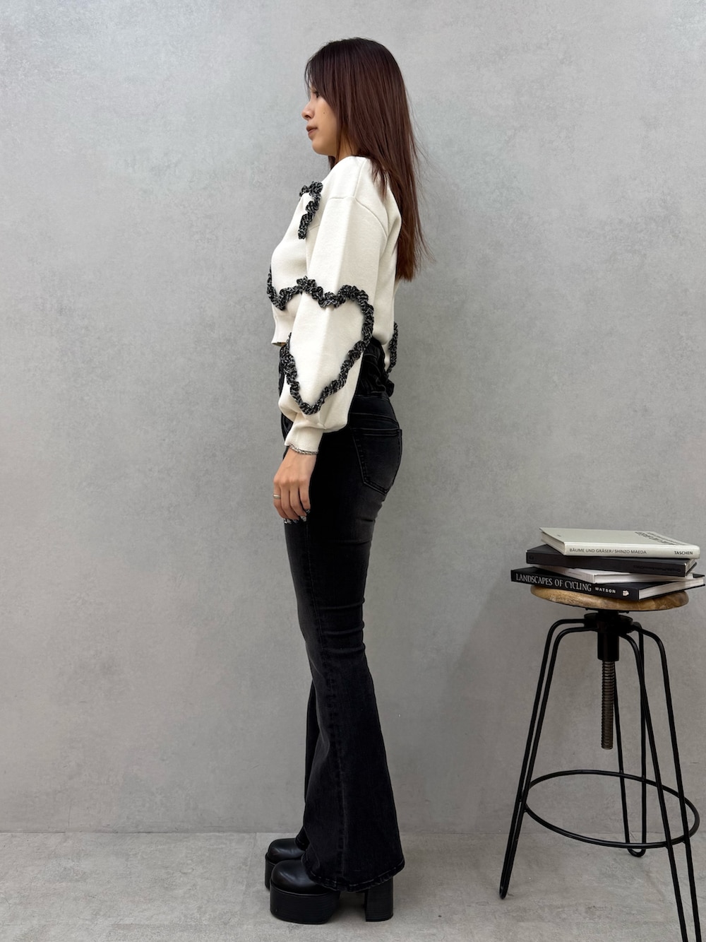 ブラック系のブーツ、ブラック系のデニムパンツ、ホワイト系のニット/セーターを着用したレディースの冬コーディネートの2枚目の写真