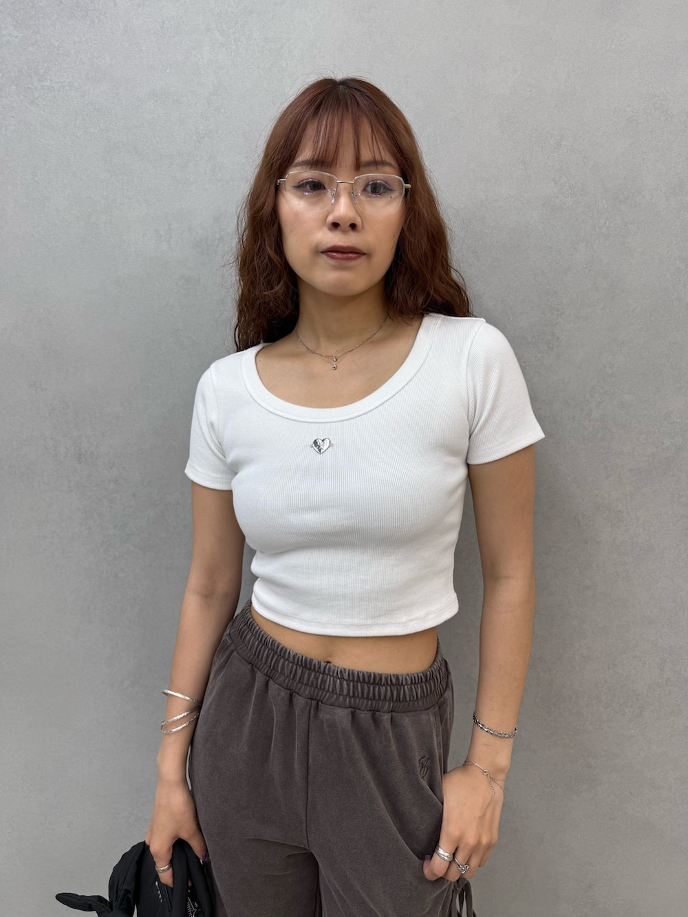 ホワイト系のTシャツ/カットソー、ブラウン系のスウェットパンツ、ブラック系のハンドバッグを着用したレディースの夏コーディネートの4枚目の写真