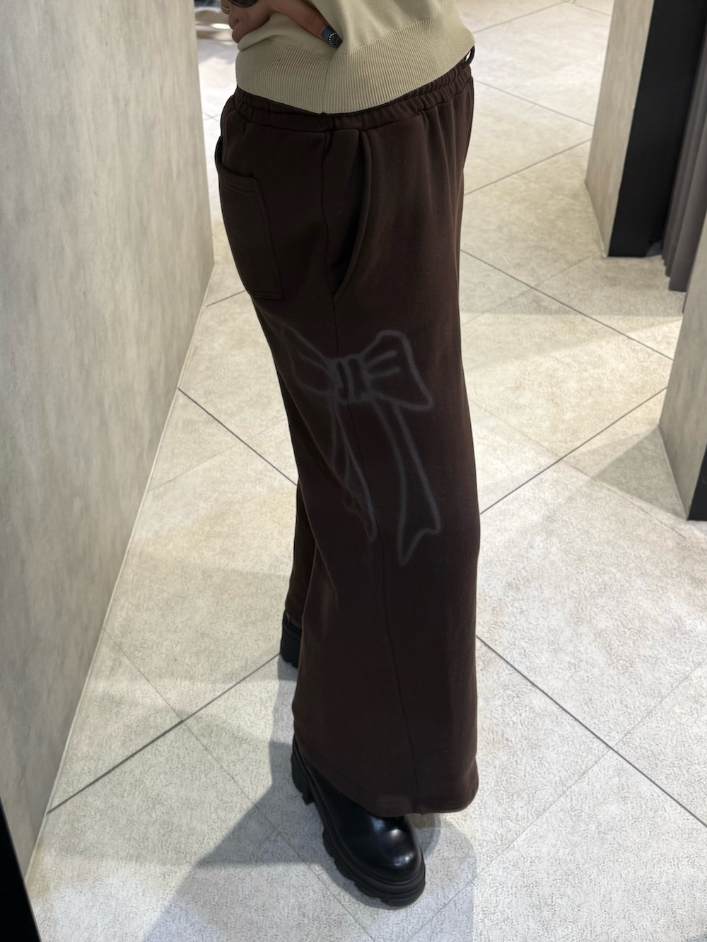 ベージュ系のシャツ/ブラウス、ブラウン系のスウェットパンツ、ブラック系のブーツを着用したレディースの冬コーディネートの5枚目の写真