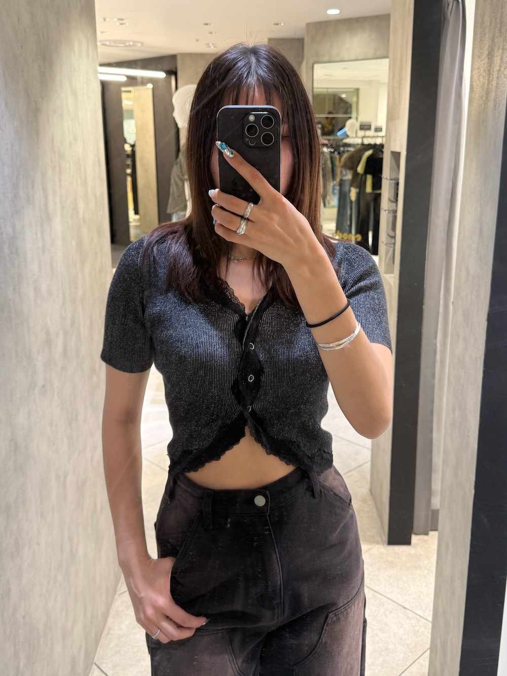 ブラック系のニット/セーター、ブラック系のデニムパンツ、ブラック系のスニーカーを着用したレディースの春コーディネートの4枚目の写真