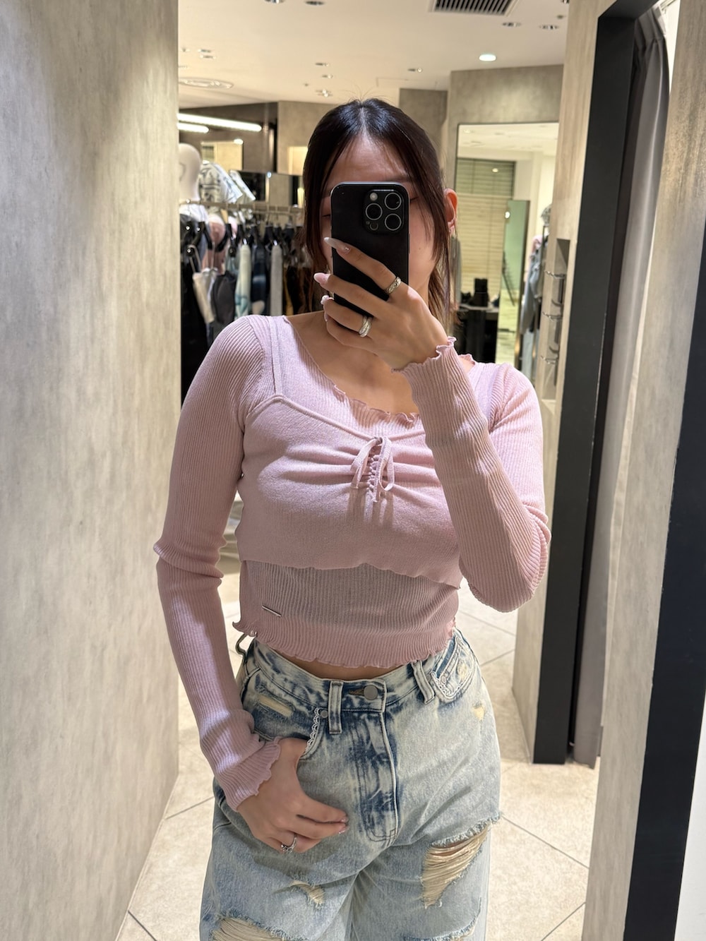 ブルー系のデニムパンツ、ブラック系のスニーカー、ピンク系のニット/セーターを着用したレディースの春コーディネートの4枚目の写真