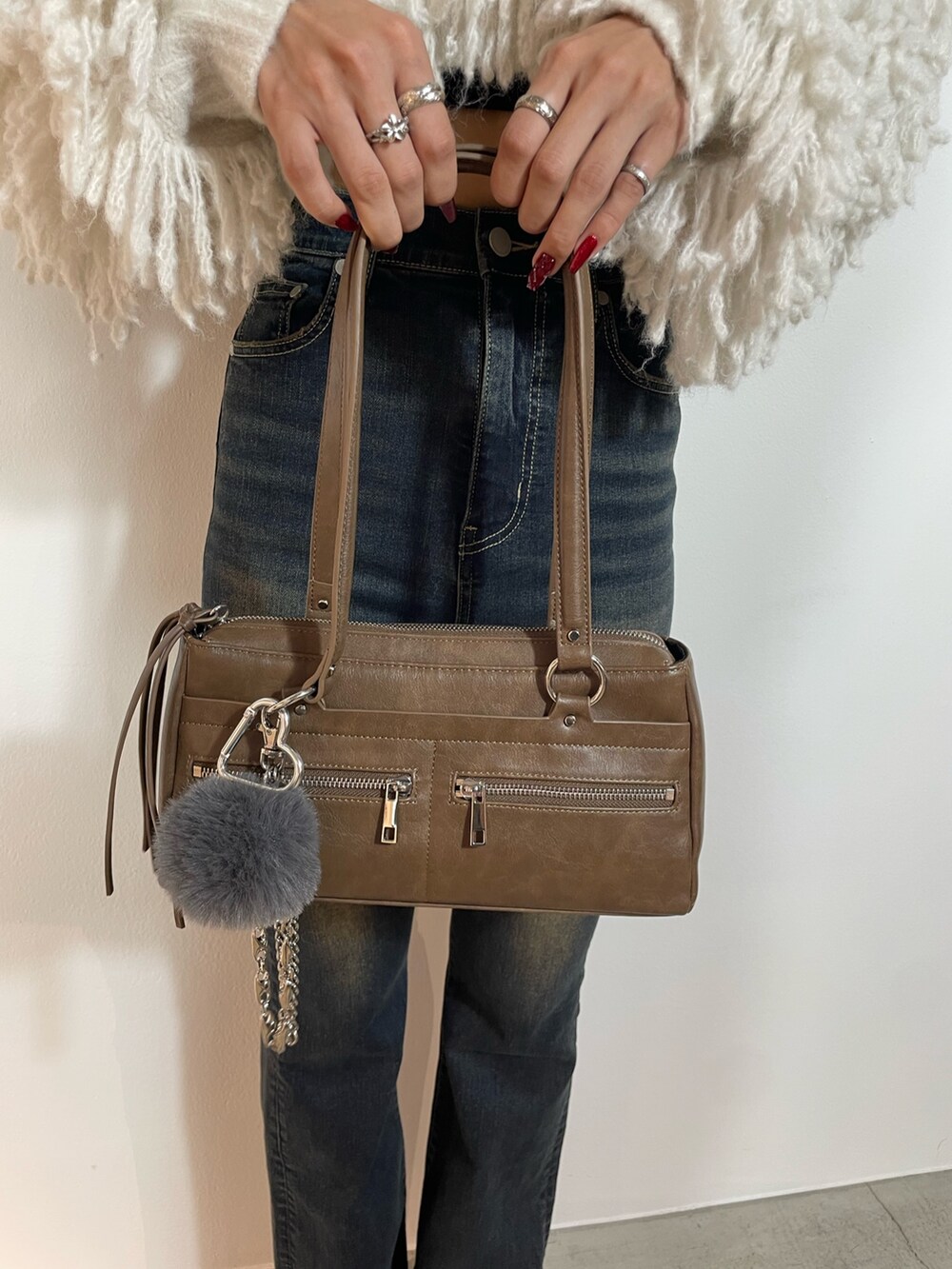 ホワイト系のニット/セーター、ブルー系のデニムパンツ、ブラウン系のショルダーバッグを着用したレディースの秋コーディネートの10枚目の写真