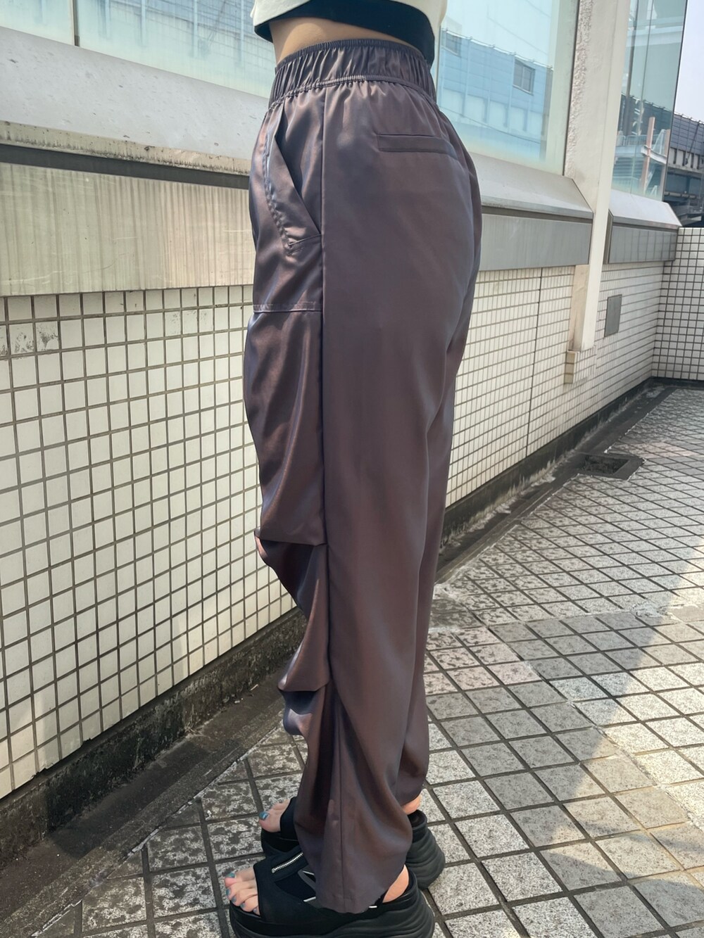 ブラック系のハンドバッグ、ブラック系のTシャツ/カットソー、ブラウン系のその他パンツを着用したレディースの春コーディネートの8枚目の写真