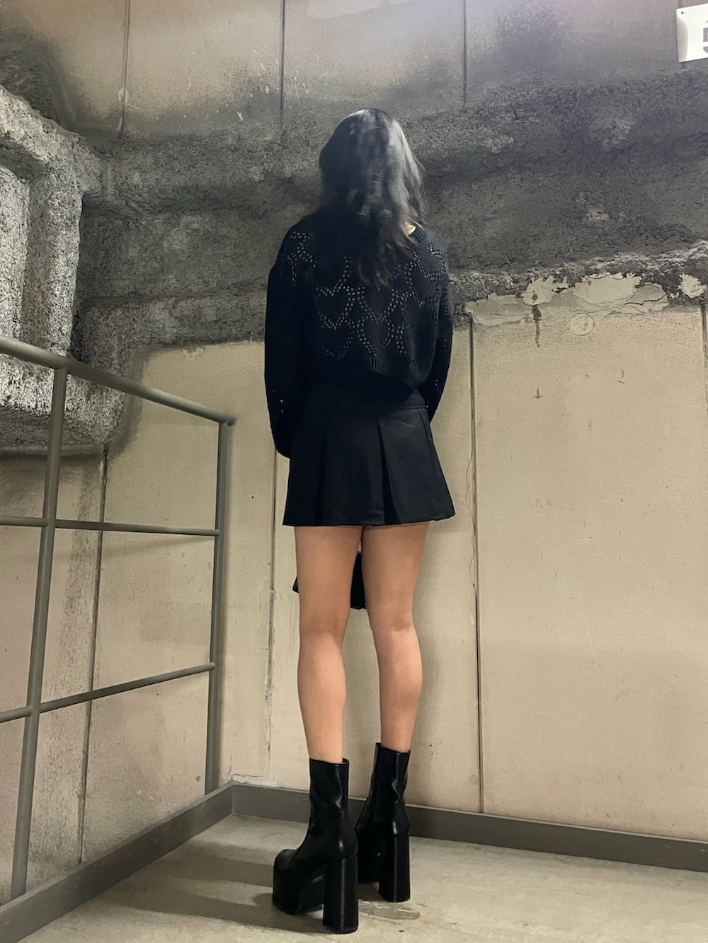 ブラック系のニット/セーター、ホワイト系のキャミソール、ブラック系のスカートを着用したレディースの春コーディネートの3枚目の写真