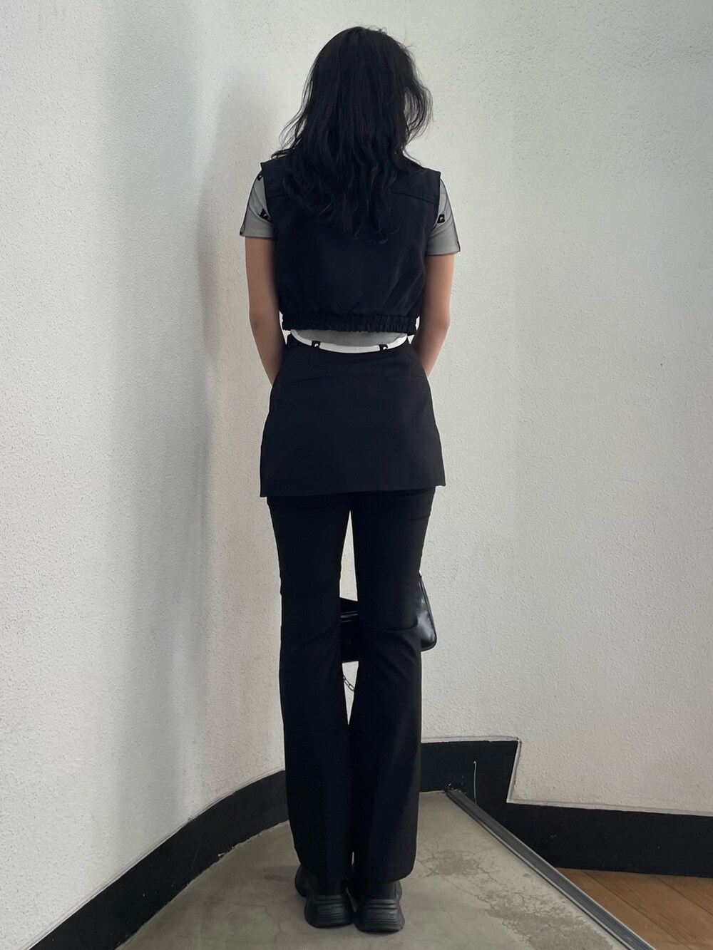 ホワイト系のTシャツ/カットソー、ブラック系のベスト、ブラック系のその他パンツを着用したレディースの春コーディネートの3枚目の写真