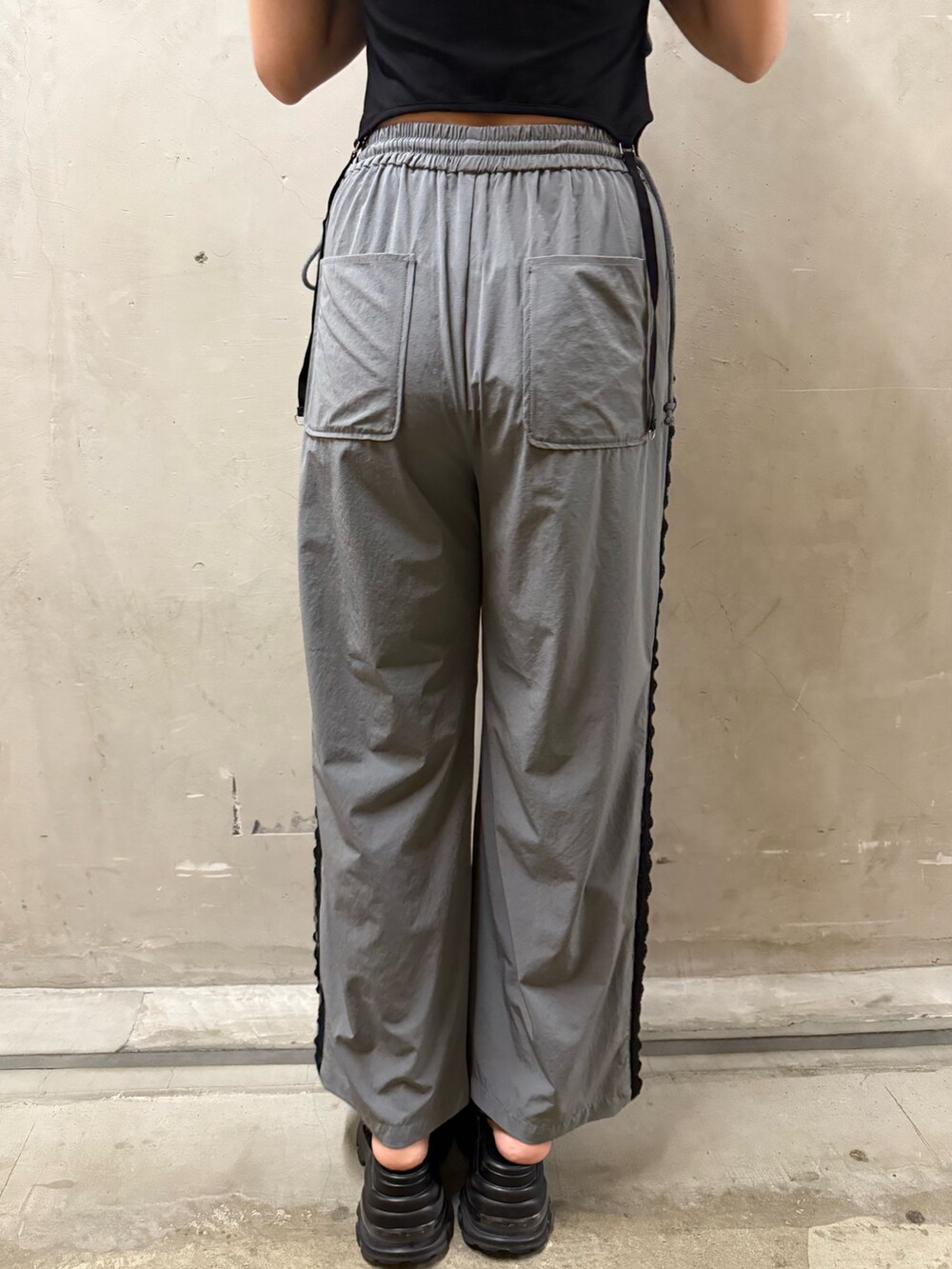 ブラック系のTシャツ/カットソー、グレー系のその他パンツ、ブラック系のハンドバッグを着用したレディースの夏コーディネートの7枚目の写真