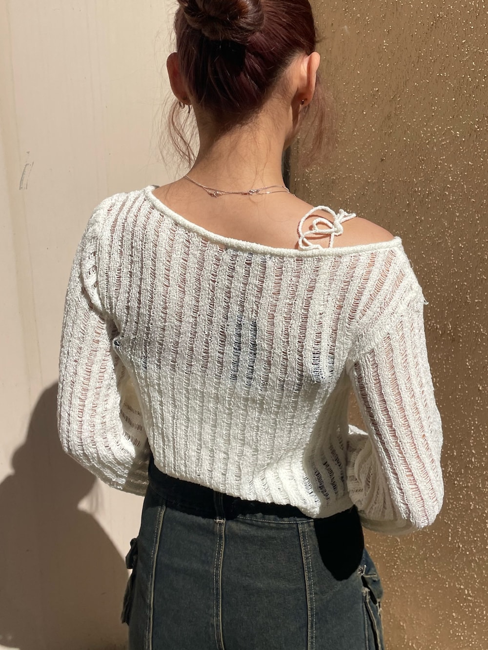 ホワイト系のニット/セーター、ブルー系のその他パンツ、ホワイト系のハンドバッグを着用したレディースの春コーディネートの6枚目の写真